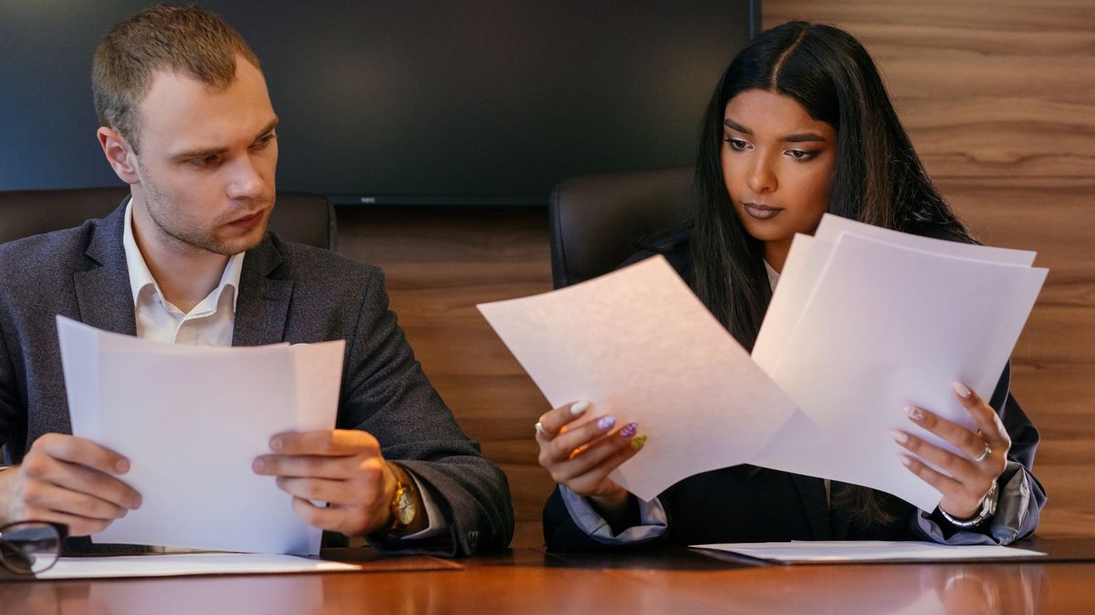Dos profesionales revisan documentos en una oficina.
